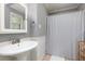 Clean bathroom featuring a pedestal sink, tiled flooring, and a shower with a striped curtain at 1167 Mcclung Rd, Hiram, GA 30141