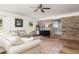 Well-lit living room with brick accent wall, hardwood floors, and view into renovated bathroom at 1167 Mcclung Rd, Hiram, GA 30141