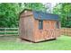 Well-built storage shed in backyard featuring double doors and decorative accents at 1167 Mcclung Rd, Hiram, GA 30141