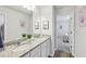 Elegant bathroom featuring a dual sink vanity with granite countertops and well-lit mirrors, creating a bright and functional space at 1421 Stephens View Dr, Loganville, GA 30052