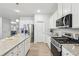 Kitchen featuring stainless steel appliances, granite countertops, kitchen island, and white cabinets at 1421 Stephens View Dr, Loganville, GA 30052