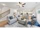 Cozy open-concept living room with ceiling fan, plush seating, and easy access to the kitchen at 1421 Stephens View Dr, Loganville, GA 30052