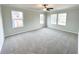 Spacious bedroom featuring plush carpet, large windows, and a ceiling fan at 5547 Bent Grass Way, Douglasville, GA 30135