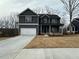 Two-story home with a two-car garage, dark gray siding, and a long driveway at 5547 Bent Grass Way, Douglasville, GA 30135