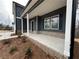 Inviting front porch with white columns, brick accents, and a dark gray door at 5547 Bent Grass Way, Douglasville, GA 30135