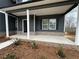 Inviting front porch with white columns, brick accents, and a dark gray door at 5547 Bent Grass Way, Douglasville, GA 30135