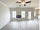 Living room with a ceiling fan, modern fireplace, and natural light from several windows at 5547 Bent Grass Way, Douglasville, GA 30135