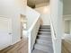 Light and airy staircase featuring carpeted steps, white railings, and wood-look floors at 5547 Bent Grass Way, Douglasville, GA 30135