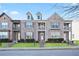 Brick front three-story townhome with landscaping and steps at 7711 Cabrini Pl, Fairburn, GA 30213