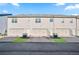 Rear view of townhomes with private garages and driveways at 7711 Cabrini Pl, Fairburn, GA 30213