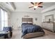 Main bedroom with upholstered headboard, ceiling fan, and ample natural light at 7711 Cabrini Pl, Fairburn, GA 30213