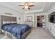 Spacious main bedroom with plush carpet and large TV at 7711 Cabrini Pl, Fairburn, GA 30213