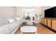 Bright living room with hardwood floors, sectional sofa, coffee table, and view to dining area at 12 Independence Nw Pl # 12, Atlanta, GA 30318