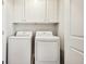 Laundry room with washer and dryer and overhead cabinets at 563 Cygnet Ln, Grayson, GA 30017