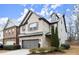 Two-story home with attached garage, landscaping and snowy scene at 8775 Village Pl, Suwanee, GA 30024