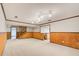 Open concept basement with neutral carpeting and wood paneling at 9385 N Lake Dr, Roswell, GA 30076