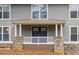 Inviting front porch with blue double doors and stone pillars at 9385 N Lake Dr, Roswell, GA 30076