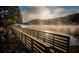 Wooden footbridge over lake with sunrise and fog at 9385 N Lake Dr, Roswell, GA 30076