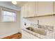 Bright laundry room with granite countertop and stainless steel sink at 9385 N Lake Dr, Roswell, GA 30076