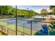 Two tennis courts by a lake with trees in background at 9385 N Lake Dr, Roswell, GA 30076