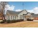 Tan house with gray roof, stone accents, and landscaping at 1003 Somerton Pl, Cumming, GA 30040