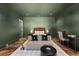 Serene bedroom with green walls, hardwood floors, and a sitting area at 230 Central Ave, Fayetteville, GA 30214