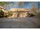 Three-car garage with light brown doors and a large concrete driveway at 5041 Towne Lake N Hls, Woodstock, GA 30189