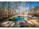 Inviting kidney-shaped pool with flagstone patio and wooded backdrop at 5041 Towne Lake N Hls, Woodstock, GA 30189