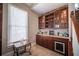 Wet bar with granite countertop, wine storage, and mini-fridge at 5041 Towne Lake N Hls, Woodstock, GA 30189