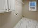 Laundry room with white cabinets, shelving and tile floor at 1206 Persimmon Way, Mcdonough, GA 30252