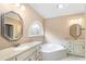 Main bathroom with double vanity, large soaking tub, and octagonal mirrors at 992 Pj East Rd, Covington, GA 30014