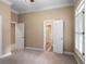 Spacious bedroom with carpet flooring, multiple doors, and window with shutters at 992 Pj East Rd, Covington, GA 30014