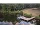 Private dock with pontoon boat on a calm lake at 992 Pj East Rd, Covington, GA 30014