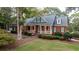 Brick home with gray roof, large porch, and landscaped yard at 992 Pj East Rd, Covington, GA 30014
