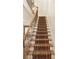 A staircase with wood railing and ornate carpeting leads to the upper level of the home at 340 Town Center Ave # 215, Suwanee, GA 30024