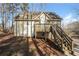 Backyard featuring a wooden deck and stairs leading to a two-story house with light siding at 380 Oak Landing Cir, Douglasville, GA 30134