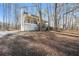 Exterior view of a two-story home featuring a welcoming front porch and beautiful wooded surroundings at 380 Oak Landing Cir, Douglasville, GA 30134