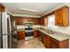 Modern kitchen with stainless steel refrigerator, oven, and sink, paired with granite counters at 380 Oak Landing Cir, Douglasville, GA 30134