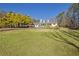 White house with stone accents, a wrap-around porch, and a large yard at 4320 Chapel Hill Farms Dr, Douglasville, GA 30135
