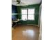 Bedroom with green and blue walls, wood flooring, and a window with natural light at 553 Wellington Way, Jonesboro, GA 30238