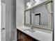 Bathroom boasts a vanity with quartz countertop and large mirror at 490 La Perla Dr, Sugar Hill, GA 30518