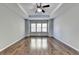 Primary bedroom with hardwood floors, tray ceiling, and ceiling fan at 490 La Perla Dr, Sugar Hill, GA 30518