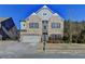 Brick two-story house with a three-car garage and landscaping at 490 La Perla Dr, Sugar Hill, GA 30518