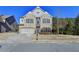 Brick two-story house with a three-car garage and landscaping at 490 La Perla Dr, Sugar Hill, GA 30518
