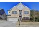 Brick two-story house with a three-car garage and landscaping at 490 La Perla Dr, Sugar Hill, GA 30518