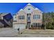 Brick two-story house with a three-car garage and landscaping at 490 La Perla Dr, Sugar Hill, GA 30518