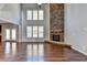 High-ceiling great room with hardwood floors, stone fireplace, and large windows at 490 La Perla Dr, Sugar Hill, GA 30518