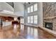 Open concept great room with kitchen views, hardwood floors, and stone fireplace at 490 La Perla Dr, Sugar Hill, GA 30518