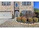 Brick facade with a two-car garage and manicured landscaping at 490 La Perla Dr, Sugar Hill, GA 30518