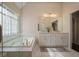 Bright bathroom featuring marble floors, a garden tub, and dual sinks with white cabinets at 366 Greycoat Sw Blf, Marietta, GA 30064